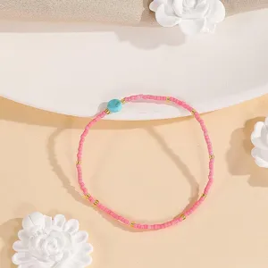Delicate beaded detail showing pink seed beads, gold accents and a natural turquoise stone bead.