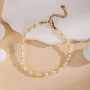 Close up detail of white and yellow beaded bracelet with gold clasp and adjustable chain