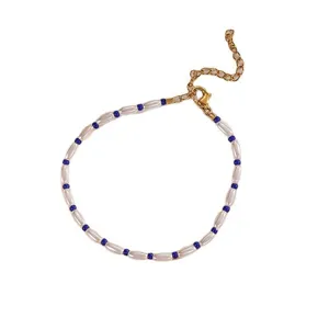 Elegant minimalist beaded bracelet with white pearls and blue seed beads, adjustable length.