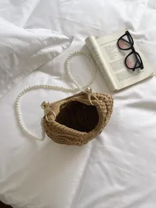 Sac à main tissé chic avec une élégante bandoulière en perles et une texture raffinée.