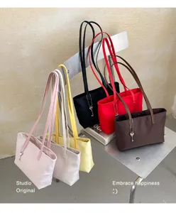 Vista dettagliata di borse tote minimaliste in nylon in vari colori posate su una sedia.