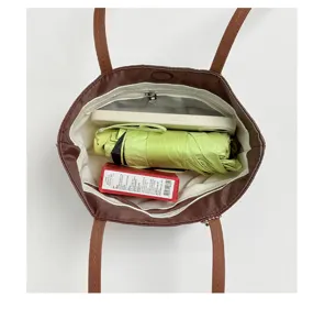 Vista dettagliata dell'interno della grande borsa tote retrò, con ampio spazio di archiviazione.