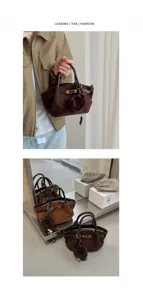 Brown suede shoulder bag detail, vintage retro handbag with soft furry pom-pom and metal clasp.