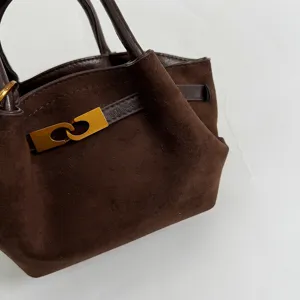 Brown suede handbag with gold clasp closure, retro minimalist design for daily use.