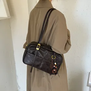 Detail view of the retro dark brown Boston shoulder bag, showing vintage metal buckle and chic charm.