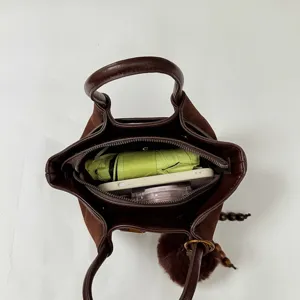 Brown suede tote bag interior detail showing large capacity, storage space, and daily items.