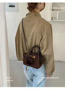 Vintage brown suede mini shoulder bag with handle and plush ball pendant chic fashion.