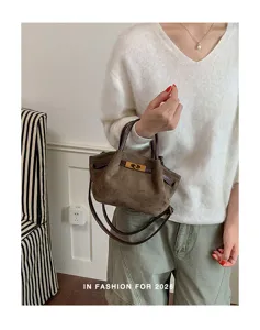 Vintage brown suede shoulder bag with metal lock, chic top handle tote for daily commuting.