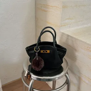 Black suede tote bag for women, elegant vintage shoulder bag with metal lock and furry charm.