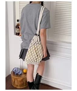 Detailed view of handmade hollow cotton knitted net shoulder bag, casual bucket bag style.