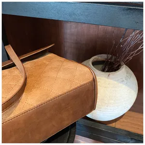 Vista dettagliata della borsa a spalla trapuntata marrone con cuciture nel set.