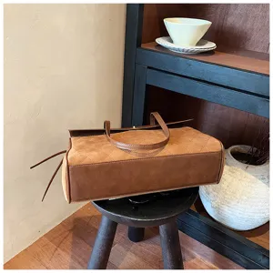 Vista dettagliata della borsa a tracolla marrone trapuntata con elegante motivo a rombi.
