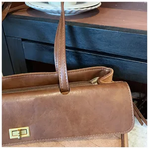 Dettaglio borsa a spalla baguette in pelle marrone vintage che mostra la patta e la chiusura.