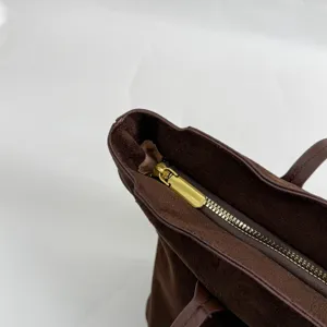 Λεπτομέρεια καφέ σουέτ τσάντας, μεταλλικό φερμουάρ κοντινό πλάνο, μινιμαλιστική τσάντα.