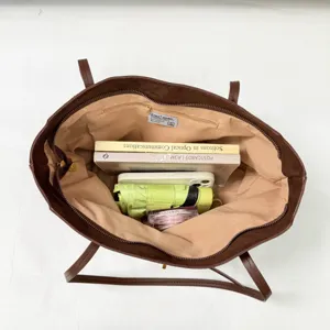 Λεπτομερής εικόνα της καφέ vintage τσάντας tote με ευρύχωρο εσωτερικό και πρακτικές θήκες.