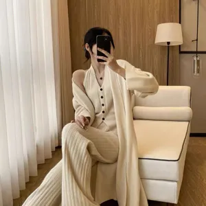 Detail van gebreide 3-delige set, zacht beige vest, top en broek in een gezellige stijl.