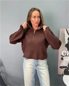 Vue détaillée du pull en tricot ample marron avec col montant et demi-fermeture éclair.