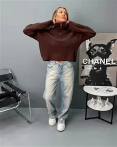 Vue détaillée d'un pull en tricot marron à demi-zip ample, mettant en valeur la texture en studio.