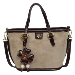 Chic beige suede tote bag with brown leather trim, detachable strap and cute flower charm.