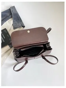 Brown oil wax leather baguette shoulder bag detail showing interior compartments and zippers.