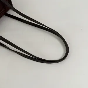 Détail de la lanière du sac à épaule en daim marron, gros plan de sac à main décontracté