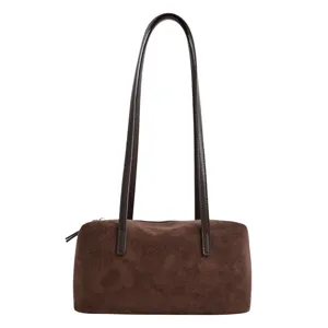 Brown suede shoulder bag detail showing long straps, smooth texture and secure side zipper.