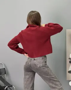Élégant pull-over à col roulé en tricot ample bordeaux pour femmes assorti à un jean gris.