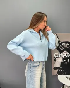Pull tricoté bleu clair demi-zip pour femme, coupe ample confortable et détails de manches.