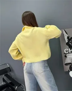 Détail pull en tricot ample à demi-zip pour femme, vêtement pullover jaune style décontracté.