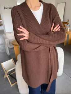 Bruin gebreid vest voor dames met V-hals, lange mouwen en bijpassende ceintuur in stijl.