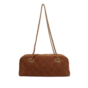 Detailed view of the brown suede quilted shoulder bag featuring elegant metal chain straps.