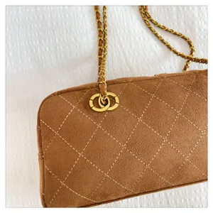 Brown suede quilted shoulder bag detail, vintage chain strap and elegant hardware design.