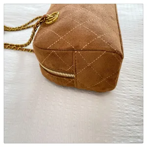 Brown suede quilted shoulder bag with gold chain strap, chic vintage design detail.