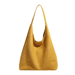 Detailed view of yellow suede hobo bag, soft texture, minimalist shoulder strap design.