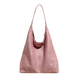 Detailed view of stylish dusty pink suede hobo shoulder bag with clean minimalist design.