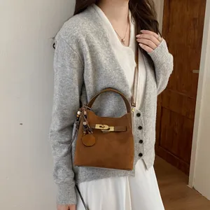 Retro suede bucket bag for women, stylish brown shoulder handbag with chic turn lock design.