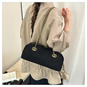Black quilted chain shoulder bag, retro baguette bowling design, stylish fashion crossbody.