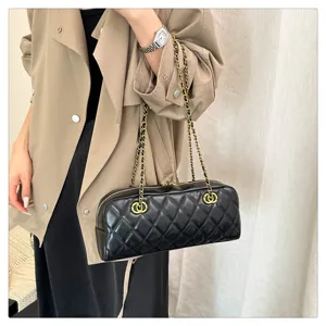 Black quilted chain shoulder bag, vintage bowling bag style with gold tone hardware.