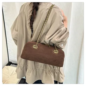 Retro brown suede bowling bag with chain strap, detailed view showing stylish shoulder wear.
