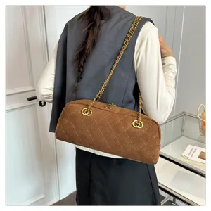 Detail view of brown suede quilted barrel shoulder bag with vintage metal chain strap.