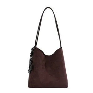 Brown suede hobo bag detail, featuring soft texture, slender strap, and delicate side tassel accent.