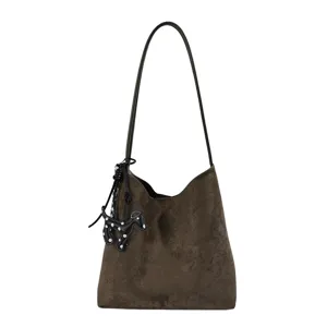 Brown suede hobo shoulder bag featuring a chic long strap and a cute polka dot dog pendant.