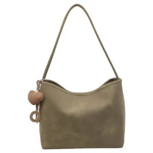 Close-up detail of olive green shoulder bag with cute heart charm and engraved ring pendant.