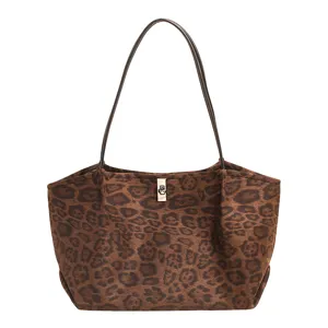 Detailed closeup of the brown leopard print tote bag, highlighting the metal clasp and straps.