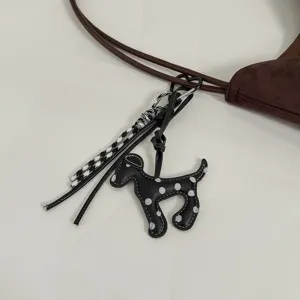 Brown suede handbag detail with cute polka dot dog charm and lanyard fashion accessory