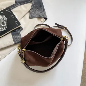 Brown suede pillow shoulder bag with metal hardware and spacious compartment for daily commuting.