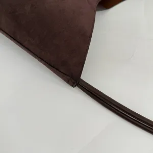 Close-up detail of dark brown suede bag strap and stitching, showcasing premium craftsmanship.