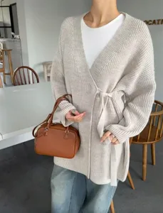 Beige gebreide wikkelcardigan trui met stijlvolle strikceintuur, comfortabele casual mode.