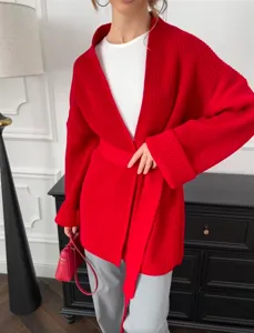 Rode gebreide cardigan detailweergave met ribtextuur, open voorkant en bijpassende riem.