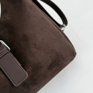 Brown suede shoulder bag detail view, casual minimalist tote bag with stylish metallic buckle.